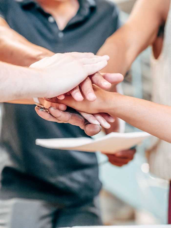 Crafting Captivating Headlines: Your awesome post title goes here Diverse team members unite hands in a symbol of partnership and success.